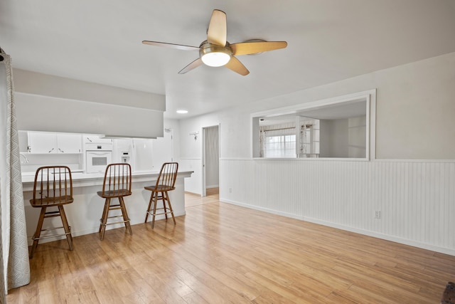 interior space with ceiling fan and light hardwood / wood-style flooring