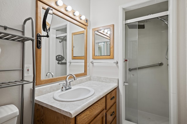 bathroom with toilet, walk in shower, and vanity