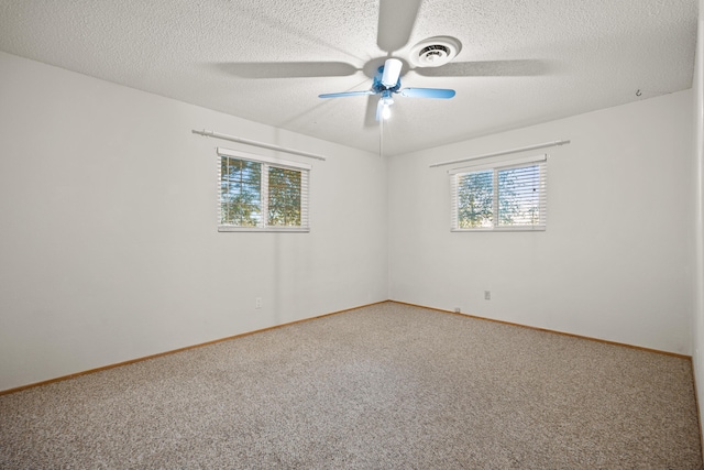 carpeted spare room featuring a textured ceiling and ceiling fan