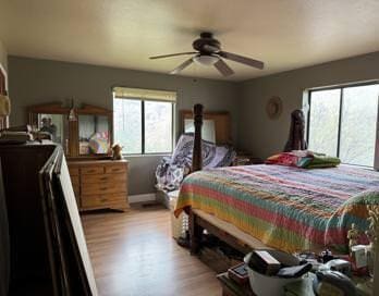 bedroom featuring multiple windows, ceiling fan, and light hardwood / wood-style flooring