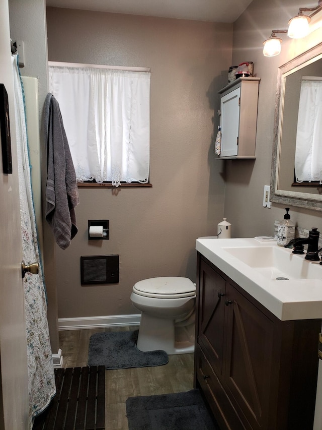 bathroom with wood-type flooring, vanity, and toilet