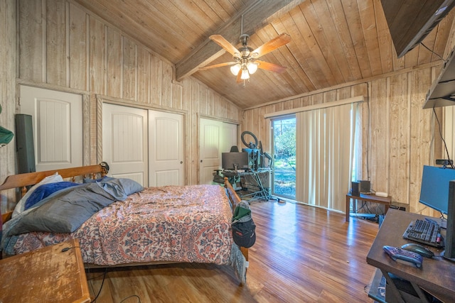 bedroom featuring multiple closets, hardwood / wood-style floors, ceiling fan, wood walls, and lofted ceiling with beams