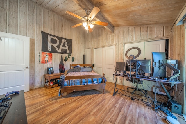 bedroom featuring hardwood / wood-style floors, wooden walls, wooden ceiling, and ceiling fan