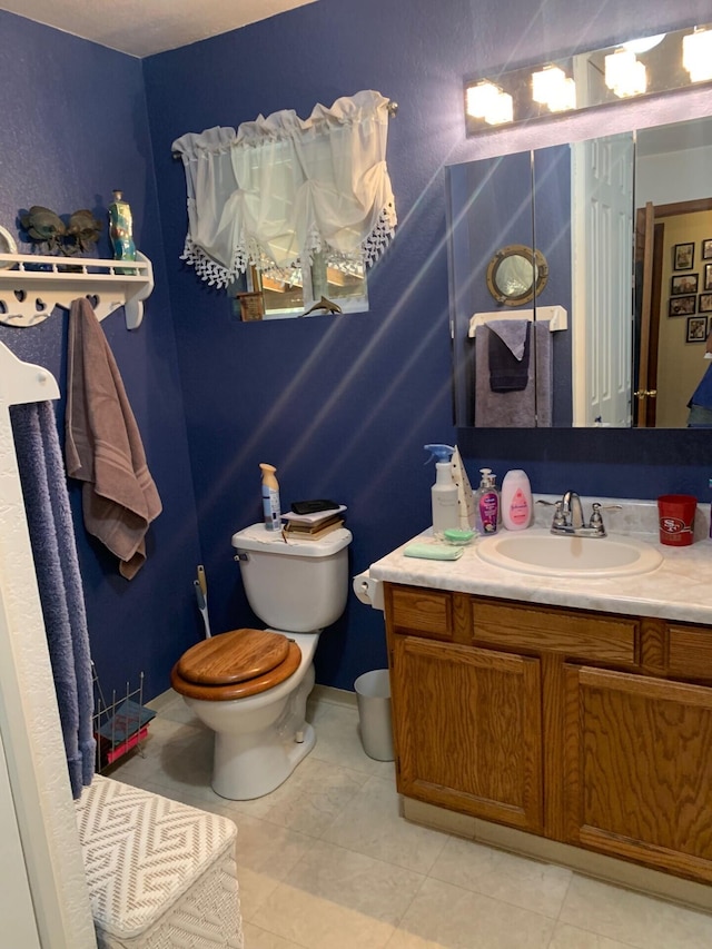 bathroom featuring tile patterned floors, vanity, and toilet