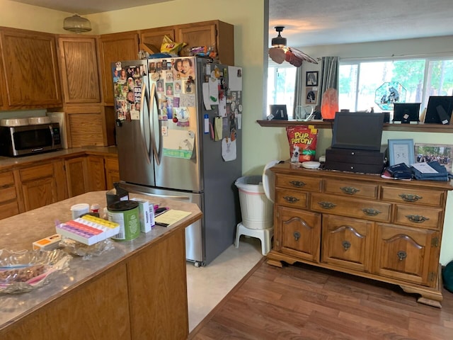 kitchen with stainless steel appliances, ceiling fan, and dark hardwood / wood-style flooring