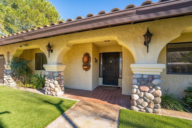 doorway to property with a lawn