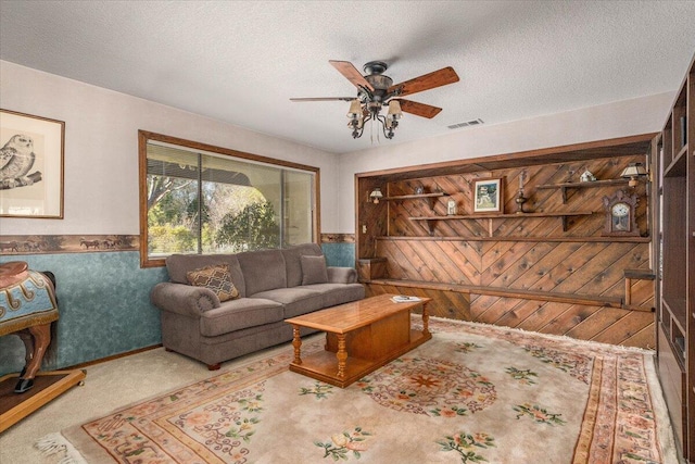 living room featuring ceiling fan and a textured ceiling