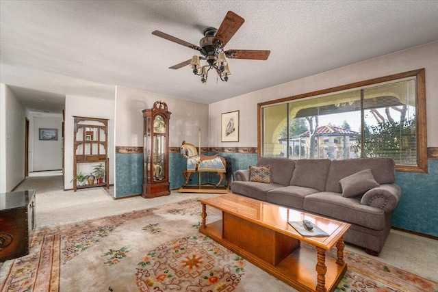 living room featuring ceiling fan and a textured ceiling