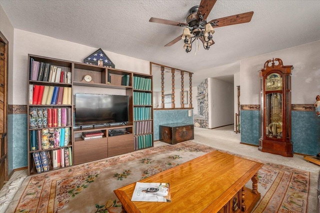 living room featuring a textured ceiling, ceiling fan, and light colored carpet