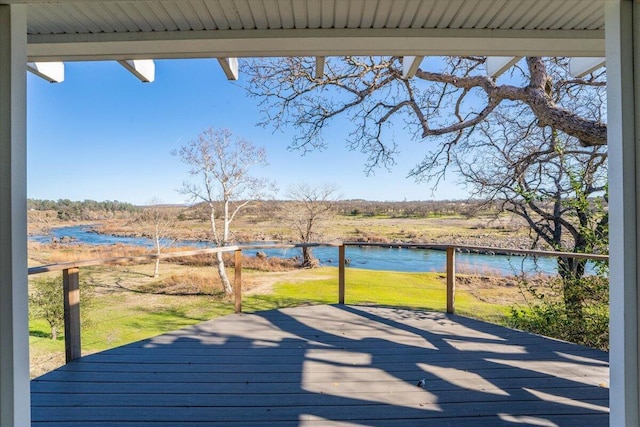 wooden deck with a yard and a water view