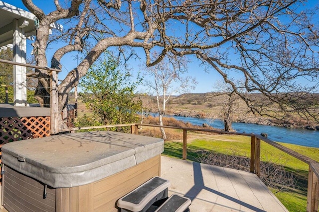 view of patio / terrace featuring a hot tub and a water view