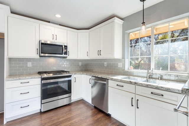 kitchen featuring backsplash, stainless steel appliances, and white cabinetry