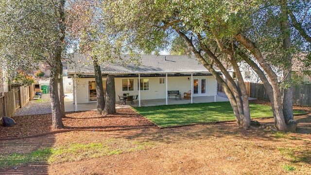 back of house with a patio area and a lawn