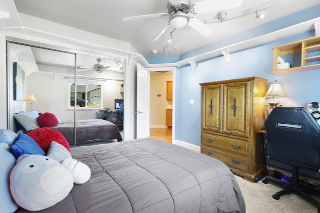 bedroom with ceiling fan, light colored carpet, and a closet