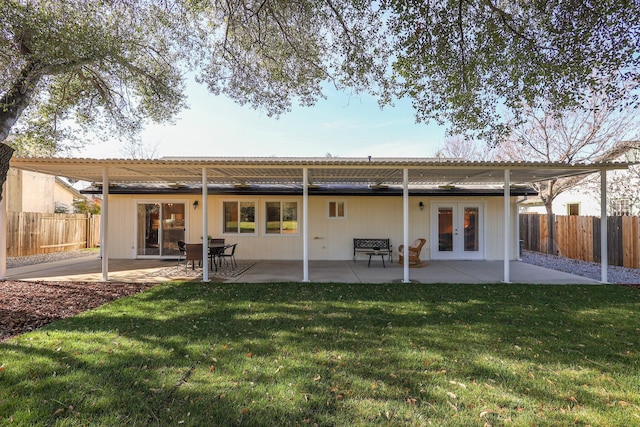 back of house with french doors, a patio, and a lawn