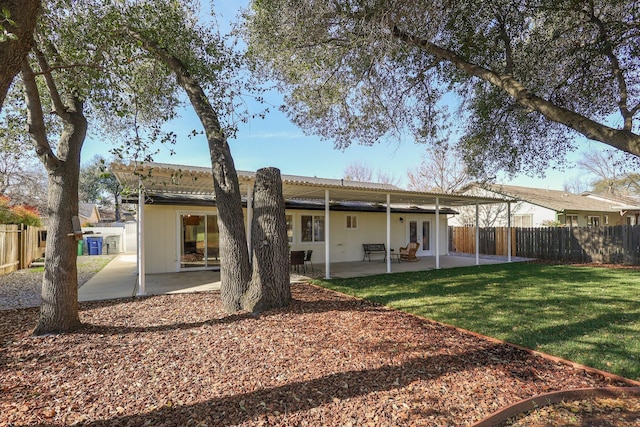 back of house featuring a lawn and a patio area