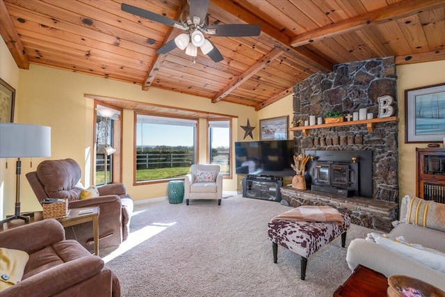 living room with wood ceiling, ceiling fan, a wood stove, vaulted ceiling with beams, and carpet flooring