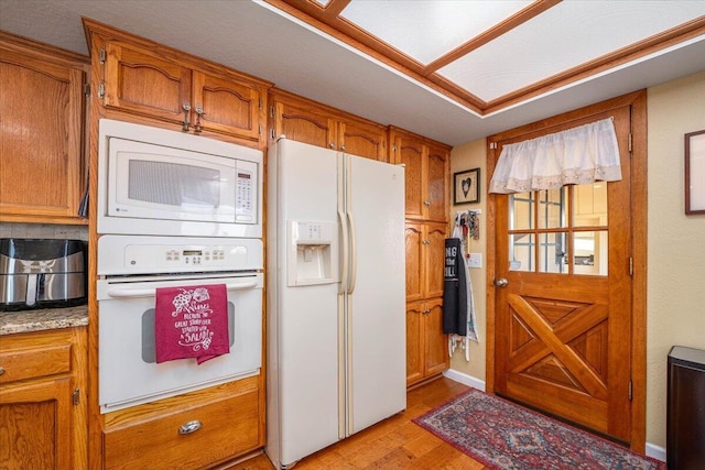 kitchen with light wood-type flooring and white appliances