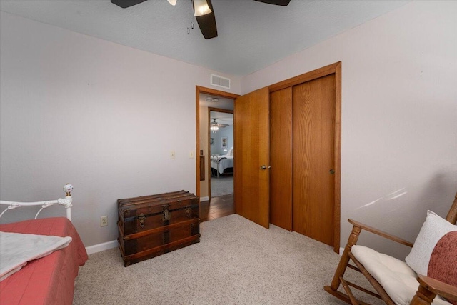 carpeted bedroom featuring ceiling fan and a closet