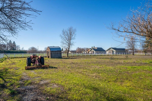 view of yard with a storage shed and a rural view