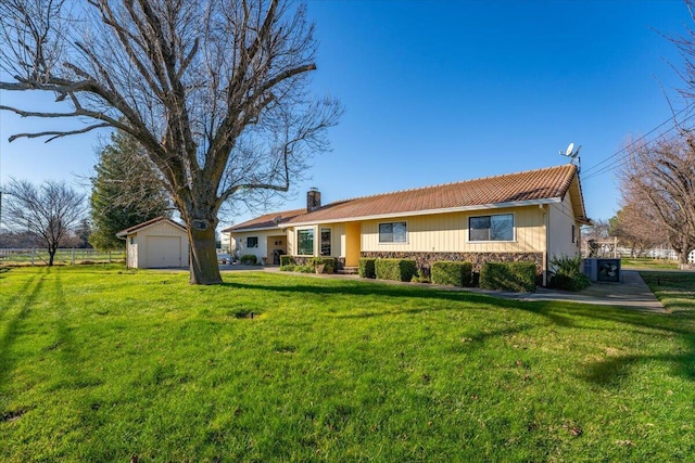 ranch-style home with an outbuilding, a front yard, and a garage