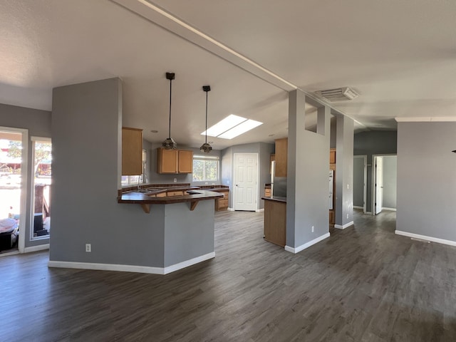 kitchen featuring decorative light fixtures, dark hardwood / wood-style floors, and kitchen peninsula