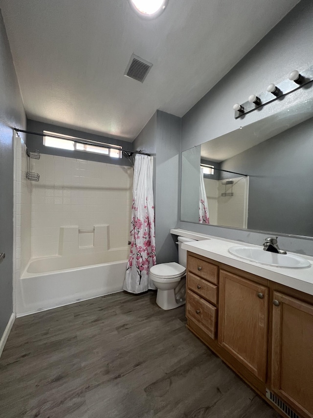 full bathroom featuring toilet, wood-type flooring, vanity, and shower / bath combo with shower curtain