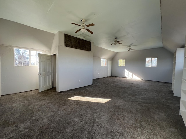 interior space with lofted ceiling, ceiling fan, and dark colored carpet