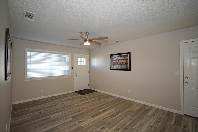 foyer entrance with a textured ceiling, ceiling fan, and dark hardwood / wood-style flooring