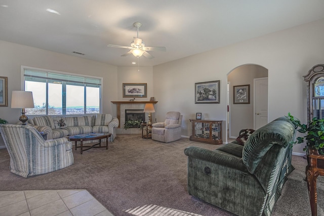 living room with a fireplace, ceiling fan, and light tile patterned flooring