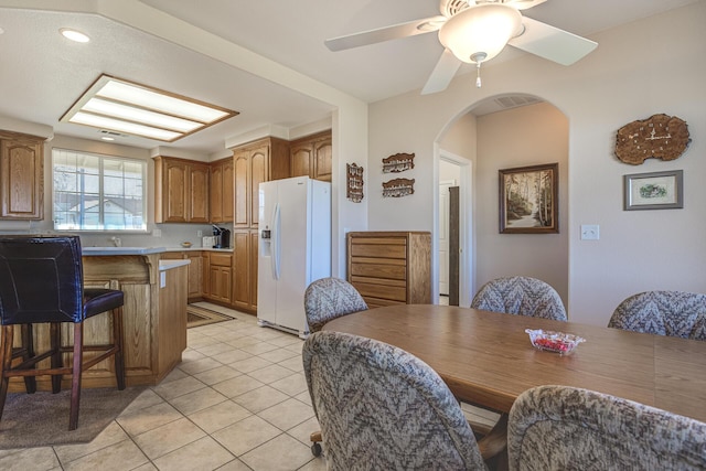 tiled dining space with ceiling fan