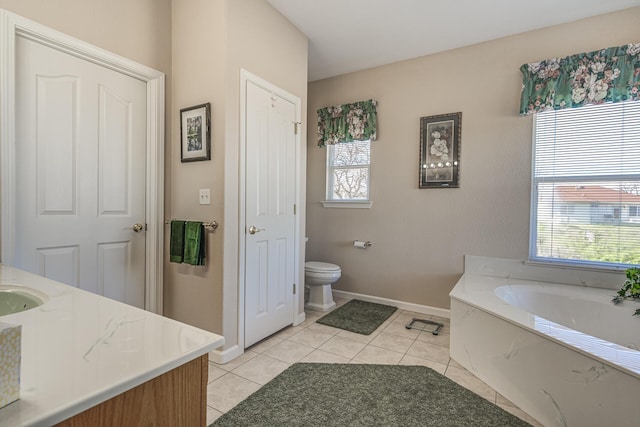 bathroom featuring tile patterned flooring, vanity, a bathtub, and toilet