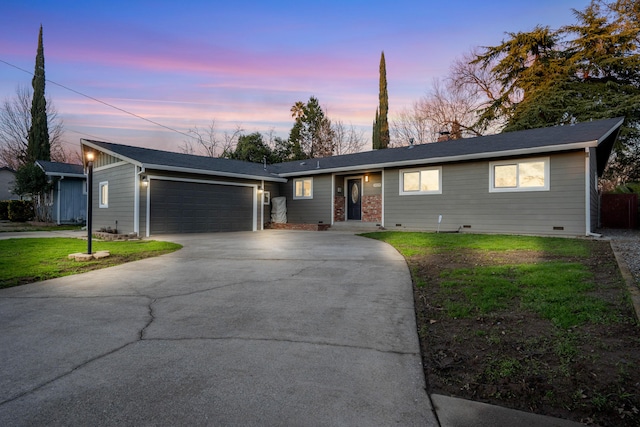 ranch-style house with a yard and a garage