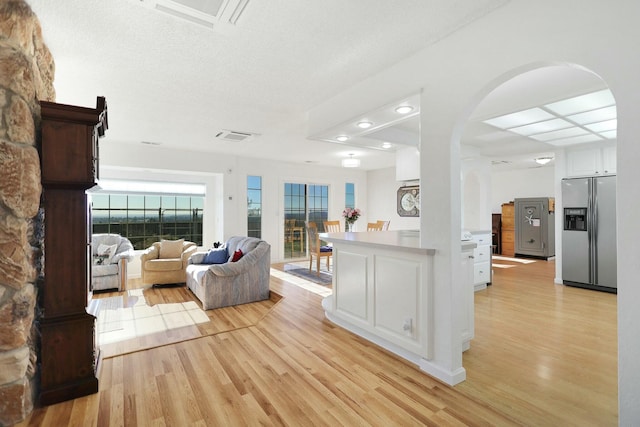 living room featuring a textured ceiling and light wood-type flooring