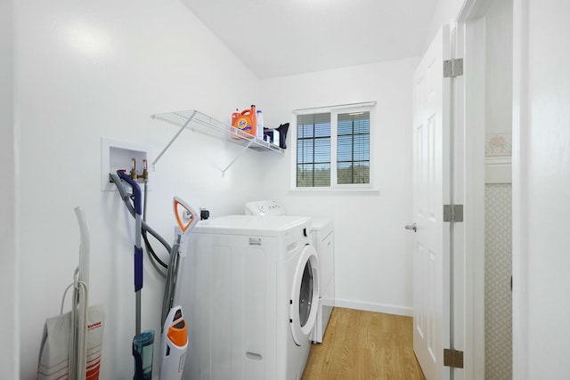 laundry area featuring washing machine and dryer and light hardwood / wood-style floors