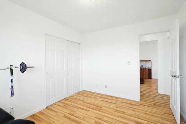 unfurnished bedroom with hardwood / wood-style flooring, a closet, and a textured ceiling