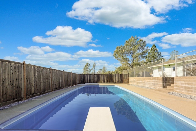 view of swimming pool featuring a diving board