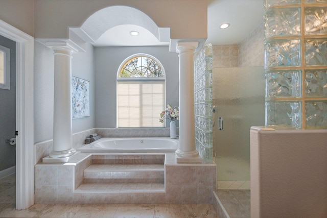 bathroom with ornate columns and shower with separate bathtub