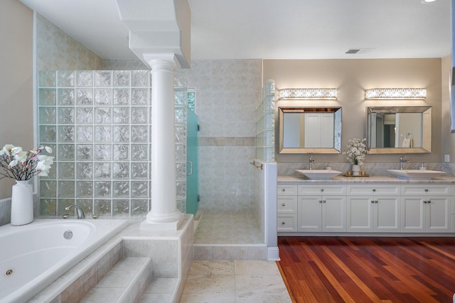 bathroom with vanity, decorative columns, plus walk in shower, and hardwood / wood-style floors