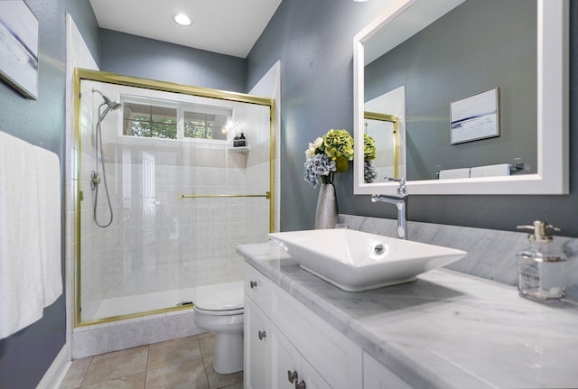 bathroom with toilet, vanity, tile patterned flooring, and an enclosed shower