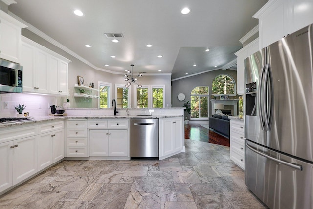 kitchen with decorative backsplash, white cabinets, appliances with stainless steel finishes, and sink