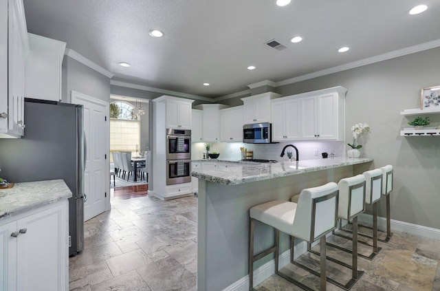 kitchen with a breakfast bar area, stainless steel appliances, kitchen peninsula, and white cabinets