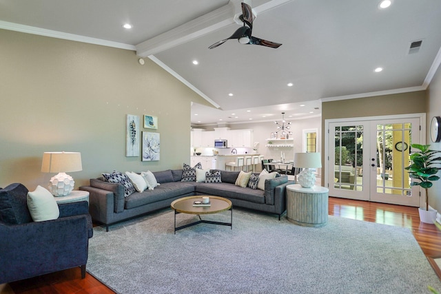 living room with wood-type flooring, french doors, ornamental molding, lofted ceiling with beams, and ceiling fan