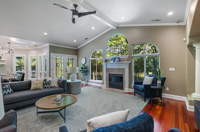 living room with a fireplace, wood-type flooring, ornamental molding, ceiling fan with notable chandelier, and lofted ceiling with beams