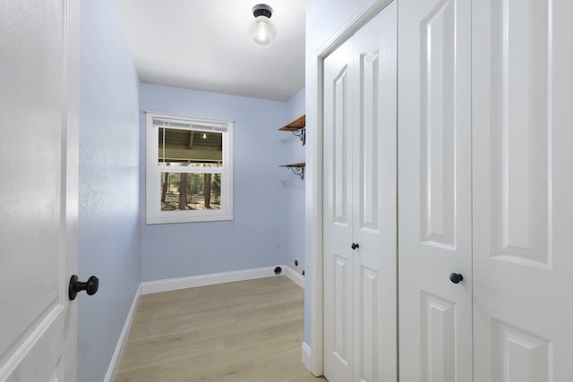 clothes washing area featuring light hardwood / wood-style floors