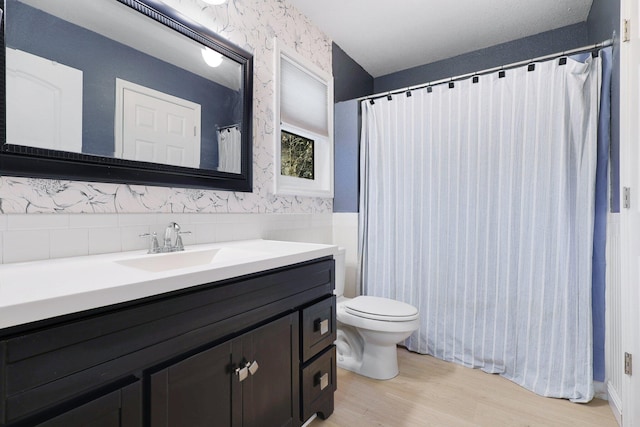 bathroom with vanity, toilet, and hardwood / wood-style floors