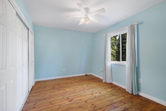 unfurnished bedroom featuring wood-type flooring, a closet, and ceiling fan