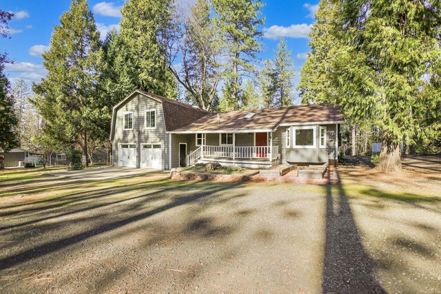 view of front of house featuring a garage, a front yard, and a porch