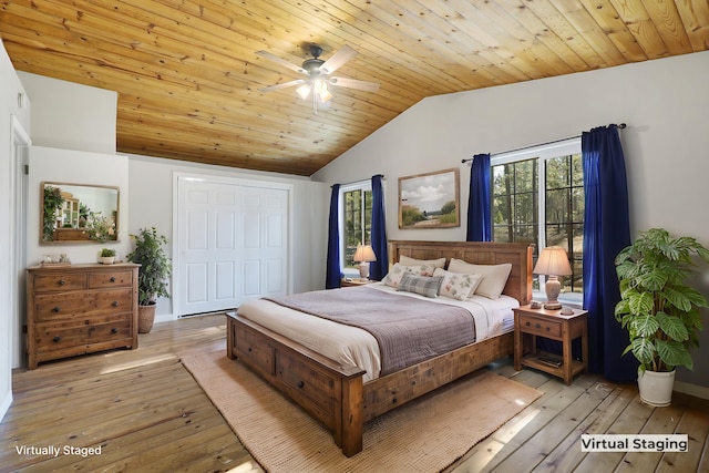 bedroom featuring vaulted ceiling, multiple windows, and light wood-type flooring