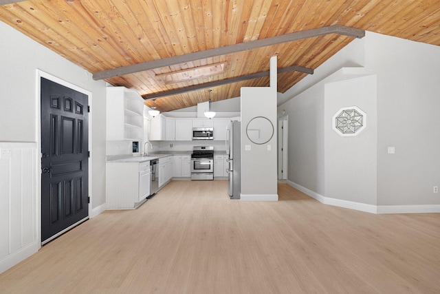 kitchen featuring pendant lighting, white cabinetry, stainless steel appliances, vaulted ceiling with skylight, and light hardwood / wood-style floors